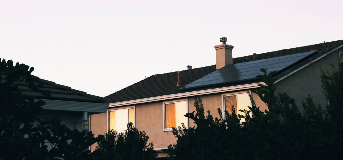Two-story home at dusk with solar panels on the roof